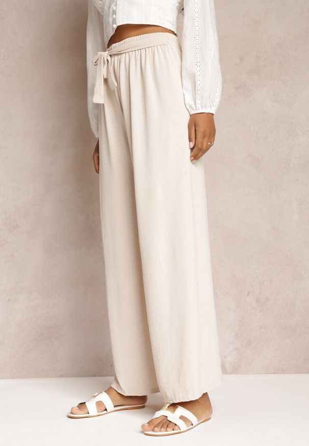 Renee - Jasnobeżowe Spodnie z Szerokimi Nogawkami i Doszytym Paskiem w Talii Atita. Kolor: beżowy