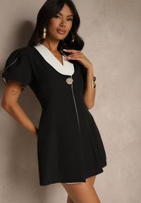 Renee - Czarna Sukienka w Stylu Retro Zdobiona Bufiastymi Rękawami i Broszką Tiazelle. Okazja: na randkę. Typ kołnierza: dekolt w kształcie V. Kolor: czarny. Wzór: aplikacja. Styl: retro