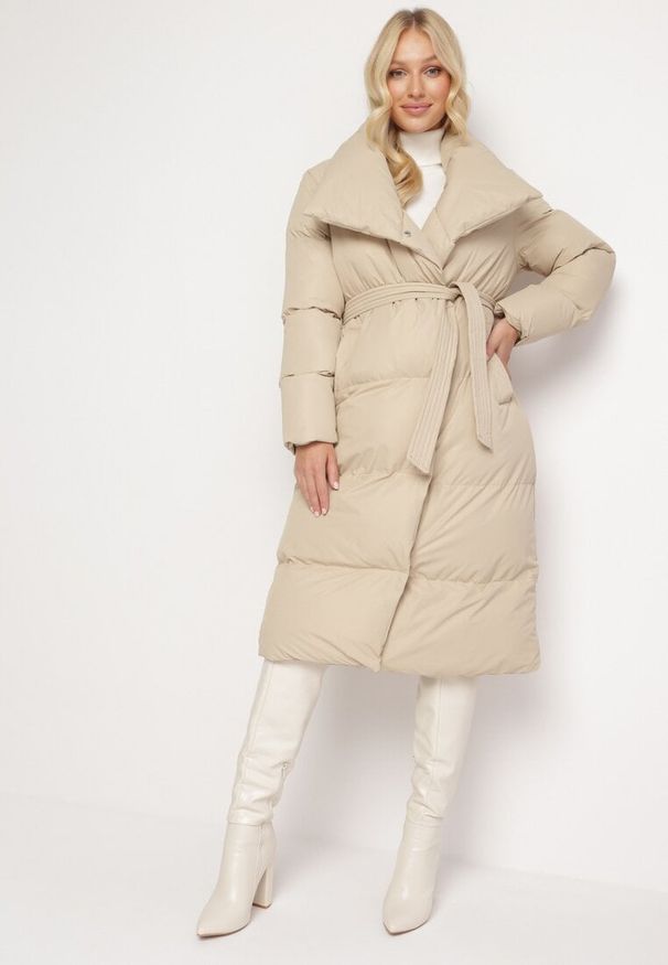 Born2be - Beżowa Kurtka Płaszcz Zapinana na Napy Ukryte pod Plisą z Kieszeniami i Paskiem Ritallas. Typ kołnierza: kołnierzyk stójkowy. Kolor: beżowy. Materiał: materiał. Długość: długie. Sezon: zima
