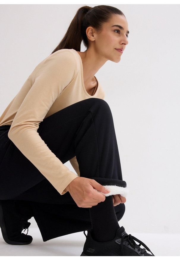 bonprix - Spodnie sportowe ocieplane, na miękkiej podszewce z polaru, szeroki fason. Kolor: czarny. Materiał: polar. Styl: sportowy