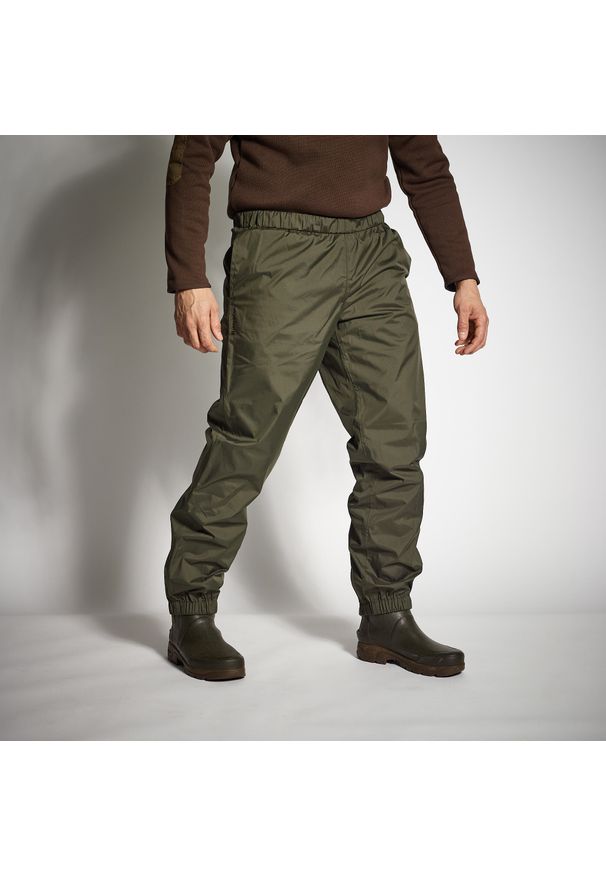 SOLOGNAC - Spodnie myśliwskie wierzchnie Solognac 100 wodoodporne. Kolor: zielony, brązowy, wielokolorowy. Materiał: materiał. Długość: krótkie