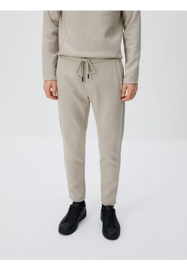 Reserved - Spodnie dresowe slim - jasnoszary. Kolor: szary. Materiał: dresówka