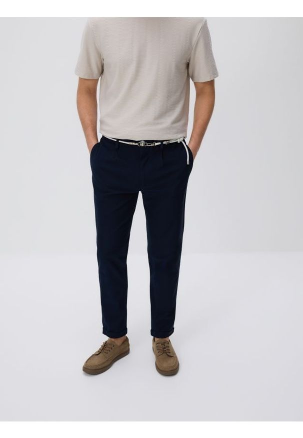 Reserved - Spodnie slim fit z paskiem - granatowy. Kolor: niebieski. Materiał: dzianina, bawełna