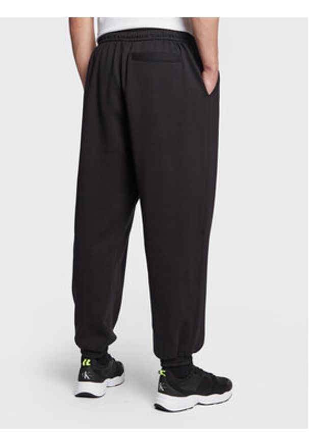 Calvin Klein Jeans Spodnie dresowe J30J322925 Czarny Relaxed Fit. Kolor: czarny. Materiał: syntetyk, bawełna