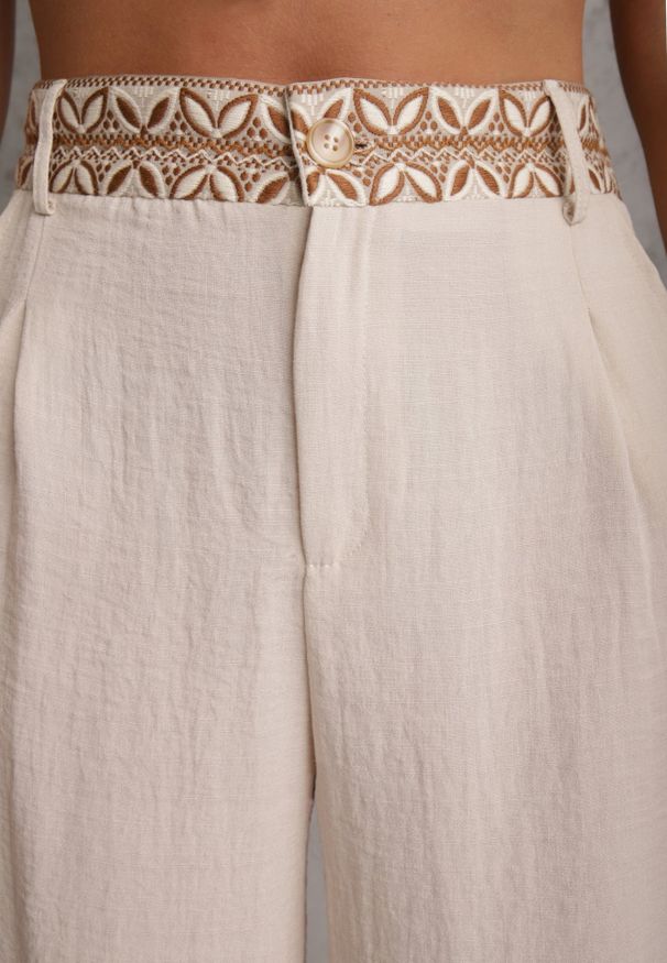 Renee - Beżowe Spodnie z Wiskozy High Waist Ozdobione Geometrycznym Motywem Iomane. Okazja: na co dzień. Stan: podwyższony. Kolor: beżowy. Materiał: wiskoza. Wzór: aplikacja, geometria. Styl: casual