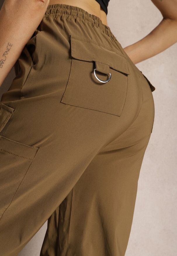 Renee - Brązowe Szerokie Spodnie High Waist w Stylu Bojówek Wykończone Gumką w Talii Ellcara. Okazja: na co dzień. Stan: podwyższony. Kolor: brązowy. Materiał: satyna. Wzór: moro. Styl: sportowy, casual, wizytowy, elegancki, militarny