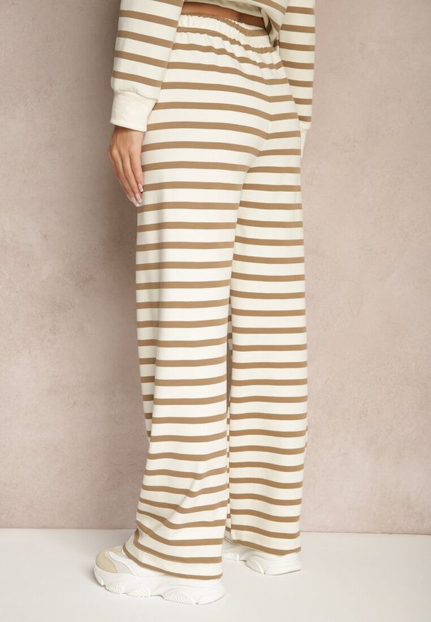 Renee - Beżowe Szerokie Spodnie Dresowe z Bawełną Ozdobione Paskami i Sznurkami Fenilira. Okazja: na co dzień. Stan: podwyższony. Kolor: beżowy. Materiał: dresówka, bawełna. Wzór: aplikacja. Styl: casual