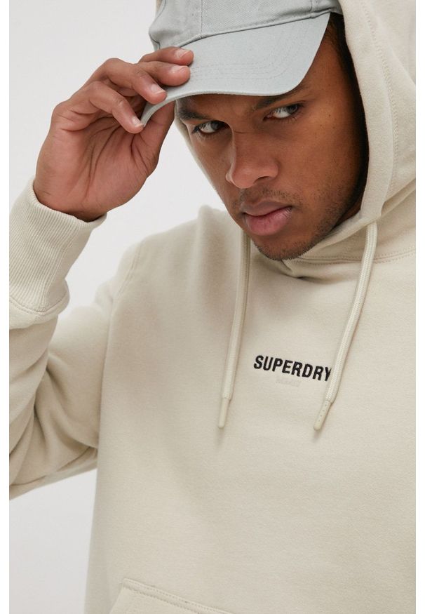 Superdry Bluza męska kolor beżowy z kapturem z aplikacją. Typ kołnierza: kaptur. Kolor: beżowy. Wzór: aplikacja
