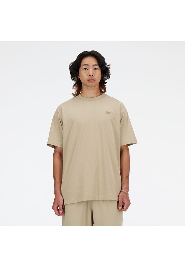 Koszulka męska New Balance MT41533SOT – beżowa. Kolor: beżowy. Materiał: bawełna, dresówka. Długość rękawa: krótki rękaw. Długość: krótkie