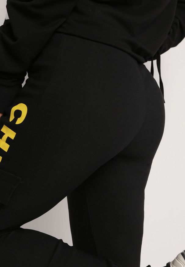 Born2be - Czarno-Żółte Spodnie Bojówki High Waist z Kopertowymi Kieszeniami i Ozdobnym Napisem Dikofina. Stan: podwyższony. Kolor: żółty. Wzór: napisy