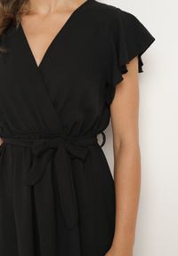 Born2be - Czarna Kopertowa Sukienka z Asymetrycznym Dołem Ozdobiona Falbanką z Paskiem w Talii Snidia. Okazja: na spacer, na co dzień. Kolor: czarny. Wzór: aplikacja. Sezon: lato. Typ sukienki: asymetryczne, kopertowe. Styl: klasyczny, casual, elegancki #5