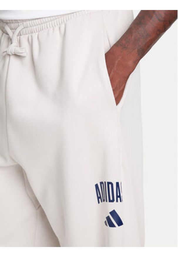 Adidas - adidas Spodnie dresowe Collegiate JM9177 Beżowy Regular Fit. Kolor: beżowy. Materiał: syntetyk, bawełna