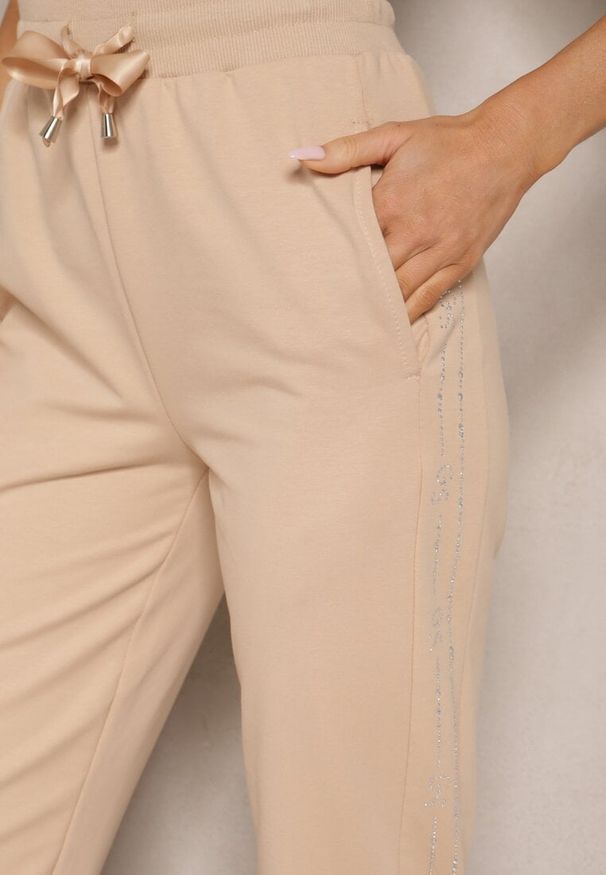 Renee - Beżowe Dresowe Spodnie z Bawełną Ozdobione Sznurkiem Anniren. Kolor: beżowy. Materiał: dresówka, bawełna. Wzór: aplikacja. Styl: klasyczny, elegancki