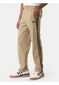 Adidas - adidas Spodnie dresowe Firebird KE6679 Beżowy Loose Fit. Kolor: beżowy. Materiał: syntetyk #1