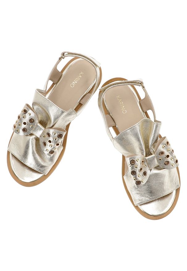 Złote Sandały Karino Modne Obuwie Damskie Z Kakardą. Okazja: na co dzień. Nosek buta: otwarty. Zapięcie: pasek. Kolor: złoty. Materiał: skóra. Sezon: lato. Styl: casual