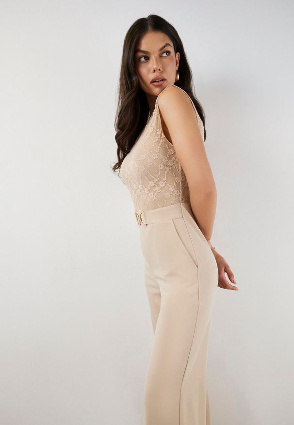 Born2be - Jasnobeżowy Kombinezon bez Rękawów z Metaliczną Ozdobą i Prostymi Nogawkami Karivalle. Okazja: na co dzień. Kolor: beżowy. Długość rękawa: bez rękawów. Wzór: aplikacja. Styl: elegancki, klasyczny, casual