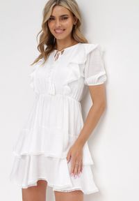 Born2be - Biała Rozkloszowana Sukienka Mini z Gumką w Talii i Koronkowymi Wstawkami Kiva. Typ kołnierza: kołnierz z falbankami. Kolor: biały. Materiał: koronka. Długość rękawa: krótki rękaw. Sezon: wiosna, lato. Długość: mini #4