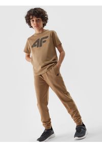 4F JUNIOR - Spodnie dresowe joggery chłopięce - beżowe. Okazja: na co dzień. Kolor: beżowy. Materiał: dresówka. Wzór: ze splotem, gładki. Styl: casual, sportowy
