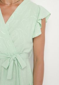 Born2be - Jasnozielona Kopertowa Sukienka Ozdobiona Falbanami i Paskiem Liliessa. Okazja: na co dzień. Typ kołnierza: dekolt w kształcie V. Kolor: zielony. Wzór: aplikacja. Typ sukienki: kopertowe. Styl: klasyczny, casual, elegancki #3