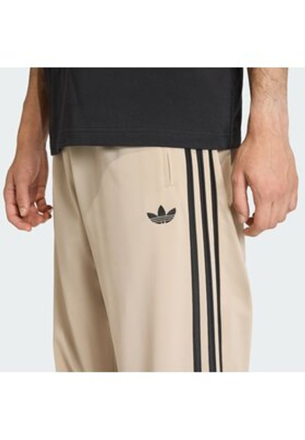 Adidas - adidas Spodnie dresowe Firebird KE6679 Beżowy Loose Fit. Kolor: beżowy. Materiał: syntetyk
