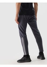 4f - Spodnie treningowe szybkoschnące męskie - ciemny szary. Kolor: szary. Materiał: syntetyk, elastan, materiał, włókno, dzianina, skóra. Wzór: ze splotem. Sport: fitness