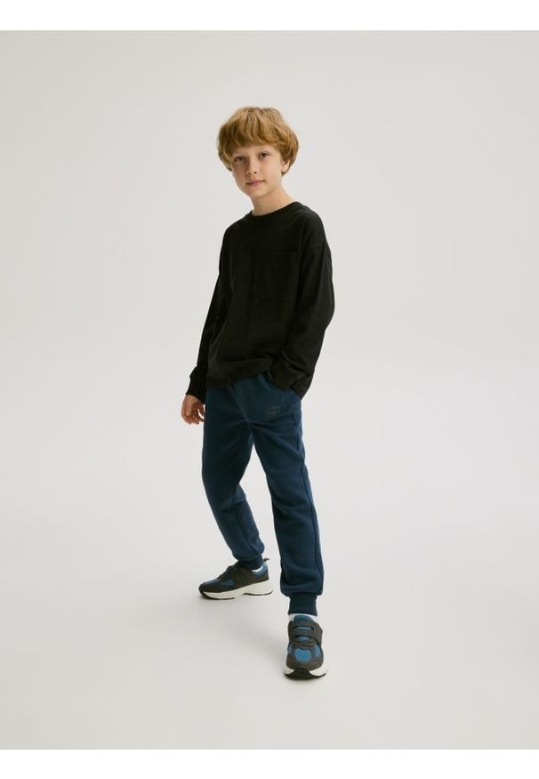 Reserved - Bawełniane joggery z meszkiem - granatowy. Kolor: niebieski. Materiał: bawełna