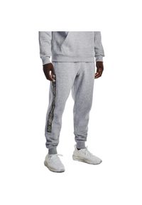 Spodnie sportowe męskie Under Armour Rival. Kolor: szary. Materiał: dresówka. Styl: sportowy. Sport: piłka nożna
