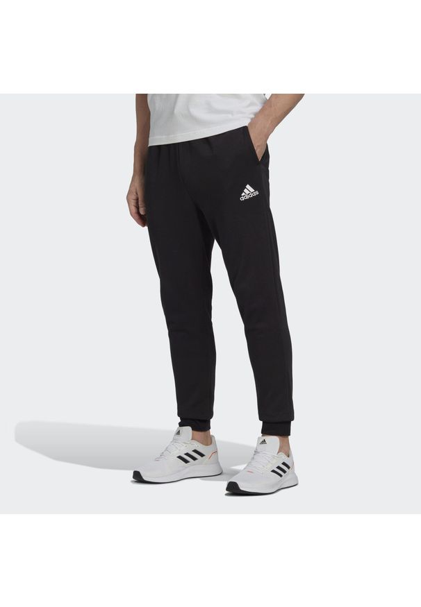 Adidas - Essentials Fleece Regular Tapered Pants. Kolor: czarny, biały, wielokolorowy. Materiał: materiał