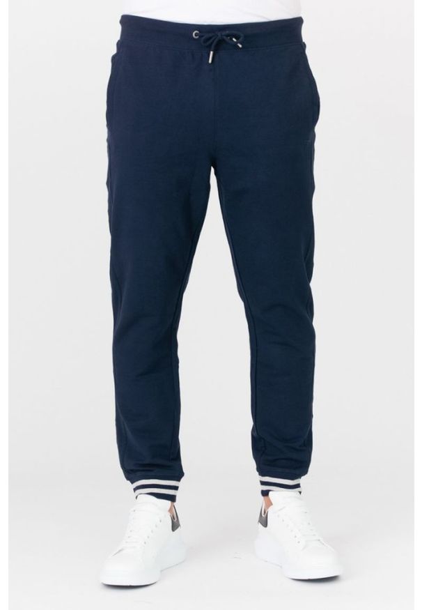 Guess - GUESS Granatowe męskie spodnie dresowe, Rozmiar XL. Kolor: niebieski. Materiał: dresówka, bawełna. Wzór: aplikacja
