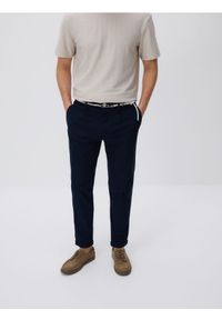 Reserved - Spodnie slim fit z paskiem - granatowy. Kolor: niebieski. Materiał: dzianina, bawełna #1