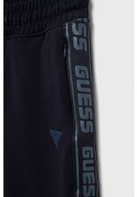 Guess spodnie dresowe dziecięce kolor granatowy z aplikacją. Okazja: na co dzień. Kolor: niebieski. Materiał: dresówka. Wzór: aplikacja. Styl: casual #3