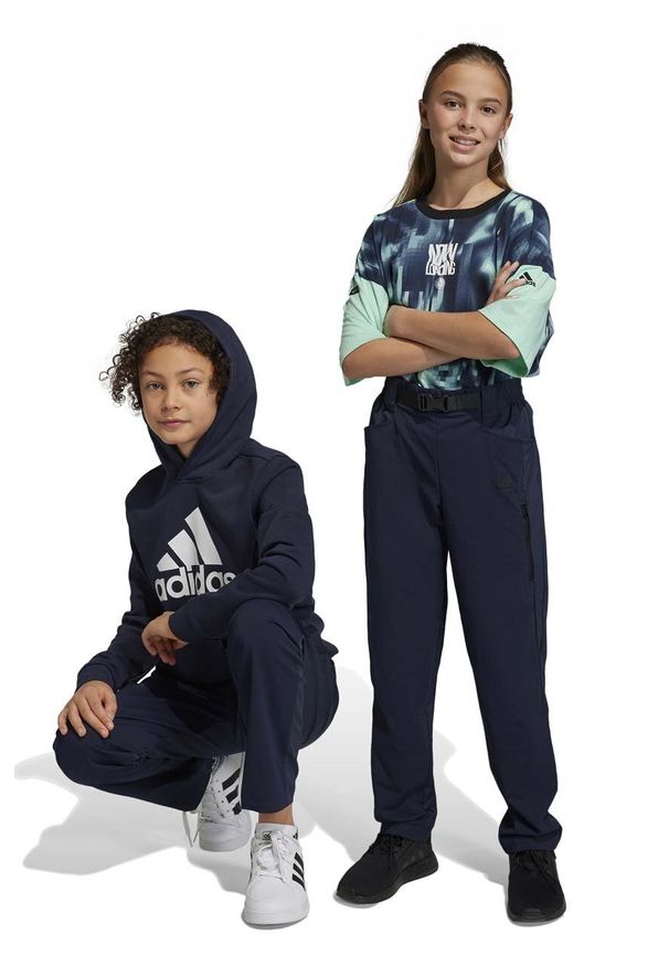 Adidas - adidas spodnie dziecięce U CE DW kolor granatowy gładkie. Kolor: niebieski. Materiał: tkanina, poliester. Wzór: gładki