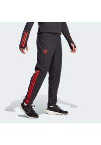 Spodnie do piłki nożnej męskie Adidas Manchester United Tiro 23 Presentation. Kolor: czarny. Materiał: dresówka, materiał