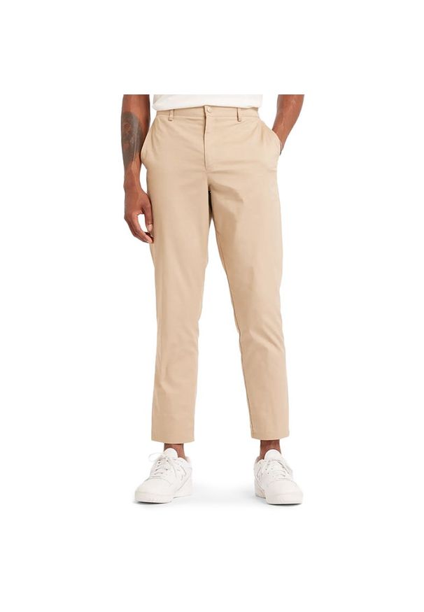 Spodnie męskie New Balance MP43554SOT - beżowe. Kolor: beżowy. Materiał: bawełna, materiał, nylon. Wzór: aplikacja