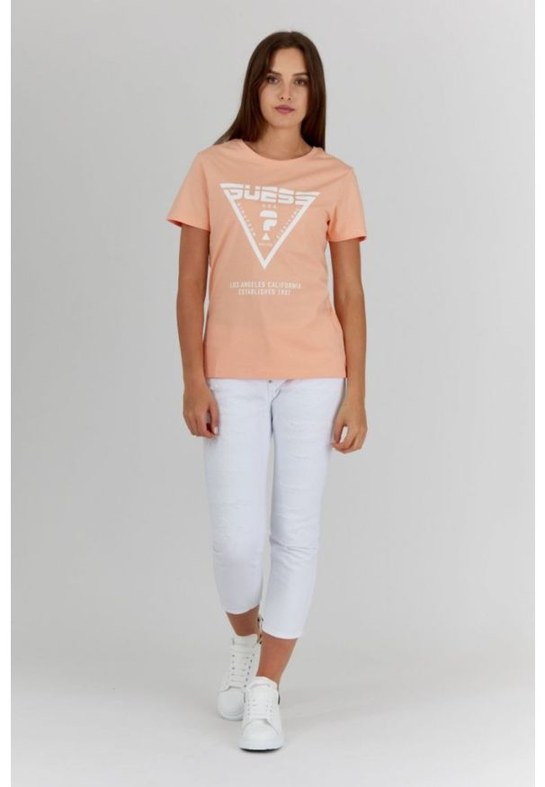 Guess - GUESS Brzoskwiniowy t-shirt damski z białym logo. Kolor: pomarańczowy. Materiał: bawełna. Wzór: nadruk