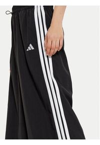 Adidas - adidas Spodnie dresowe Essentials 3-Stripes JE1306 Czarny Loose Fit. Kolor: czarny. Materiał: syntetyk