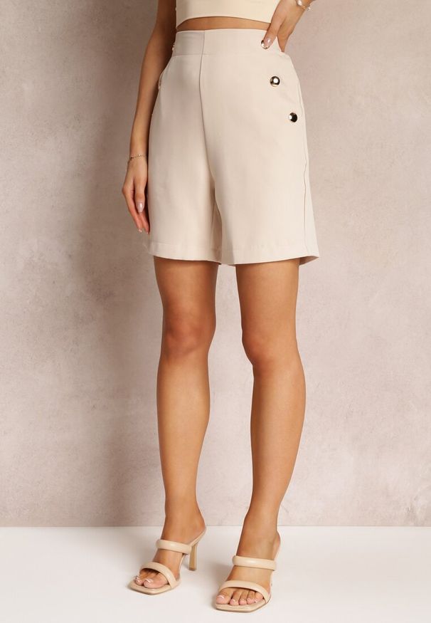 Renee - Jasnobeżowe Dopasowane Szorty z Eleganckimi Guzikami i Wsuwanymi Kieszeniami Reitza. Stan: podwyższony. Kolor: beżowy. Sezon: lato. Styl: elegancki