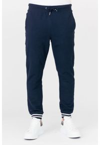 Guess - GUESS Granatowe męskie spodnie dresowe. Kolor: niebieski. Materiał: bawełna. Wzór: aplikacja