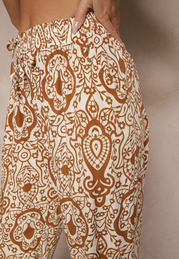Renee - Brązowe Wiskozowe Spodnie High Waist Zdobione Ornamentalnym Printem Jenavitha. Stan: podwyższony. Kolor: brązowy. Materiał: wiskoza. Wzór: aplikacja, nadruk. Sezon: lato, wiosna. Styl: klasyczny, elegancki