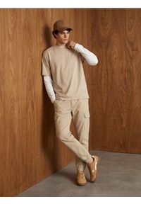 Sinsay - Bawełniane spodnie relaxed cargo jogger - beżowy. Kolor: beżowy. Materiał: bawełna