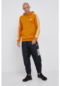 Adidas - adidas Bluza męska kolor pomarańczowy z kapturem gładka. Okazja: na co dzień. Typ kołnierza: kaptur. Kolor: pomarańczowy. Materiał: bawełna, dzianina, materiał. Wzór: gładki, aplikacja. Styl: casual