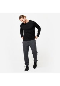 DOMYOS - Koszulka z długim rękawem męska Domyos Gym & Pilates 100. Kolor: czarny. Materiał: materiał, prążkowany, bawełna, tkanina, elastan. Długość rękawa: długi rękaw. Długość: długie. Wzór: ze splotem. Sport: joga i pilates