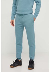 Guess spodnie dresowe kolor zielony melanżowe. Kolor: turkusowy. Materiał: dresówka. Wzór: melanż