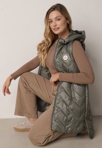 Born2be - Zielona Przejściowa Kamizelka Pikowana o Długim Kroju z Kapturem i Naszywką Harmaste. Okazja: na co dzień. Typ kołnierza: kaptur. Kolor: zielony. Materiał: jeans. Długość: długie. Wzór: aplikacja. Styl: casual #6