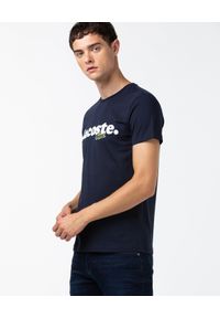 Lacoste - LACOSTE - Granatowy t-shirt z nadrukiem logo. Kolor: niebieski. Materiał: bawełna, jeans. Wzór: nadruk. Styl: sportowy, klasyczny