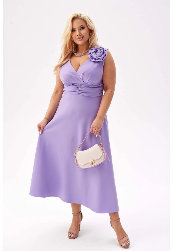 Moda Size Plus Iwanek - Elegancka sukienka Anna na wesele w lawendowym kolorze PLUS SIZE XXL. Okazja: na wesele, na ślub cywilny. Typ kołnierza: dekolt kopertowy. Kolekcja: plus size. Kolor: fioletowy. Wzór: aplikacja, kwiaty. Typ sukienki: dla puszystych. Materiał: tkanina, elastan, poliester. Styl: elegancki. Długość: midi