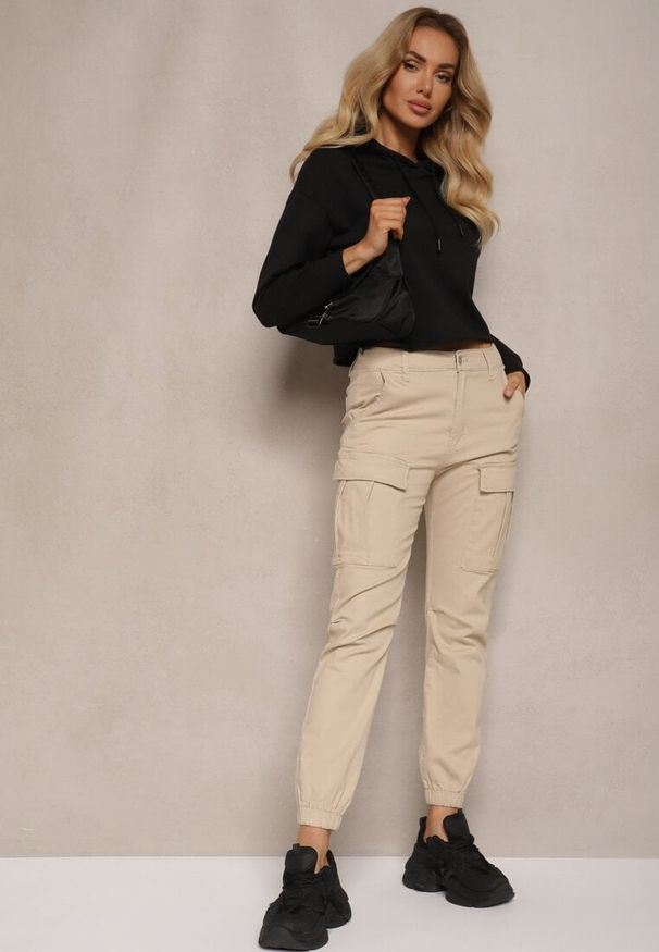 Renee - Beżowe Jeansy z Bawełny o Kroju Joggerów z Ozdobnymi Kieszeniami i Gumką w Pasie Unicella. Okazja: na co dzień. Kolor: beżowy. Styl: casual