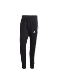 Adidas - Essentials French Terry Tapered Cuff 3-Stripes Pants. Kolor: biały, wielokolorowy, czarny. Materiał: dresówka
