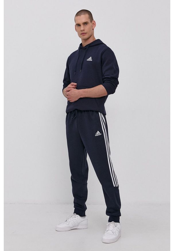 Adidas - adidas Spodnie męskie kolor granatowy gładkie. Kolor: niebieski. Materiał: materiał, bawełna. Wzór: gładki
