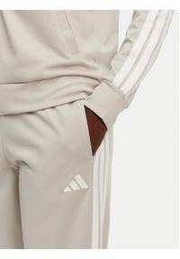 Adidas - adidas Dres Essentials 3-Stripes JD2686 Beżowy Regular Fit. Kolor: beżowy. Materiał: syntetyk